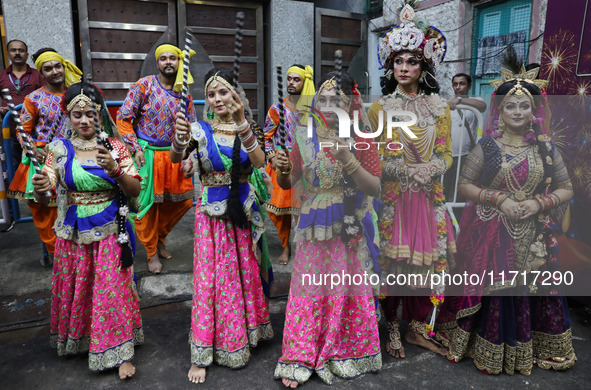 Artists perform during an inauguration program next to a ''pandal'' (a temporary platform), a decorated structure, next to an idol of the Hi...