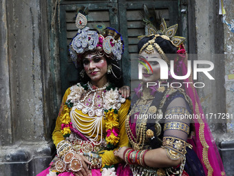 Artists rest after performing an inauguration program next to a ''pandal'' (a temporary platform), a decorated structure, next to an idol of...