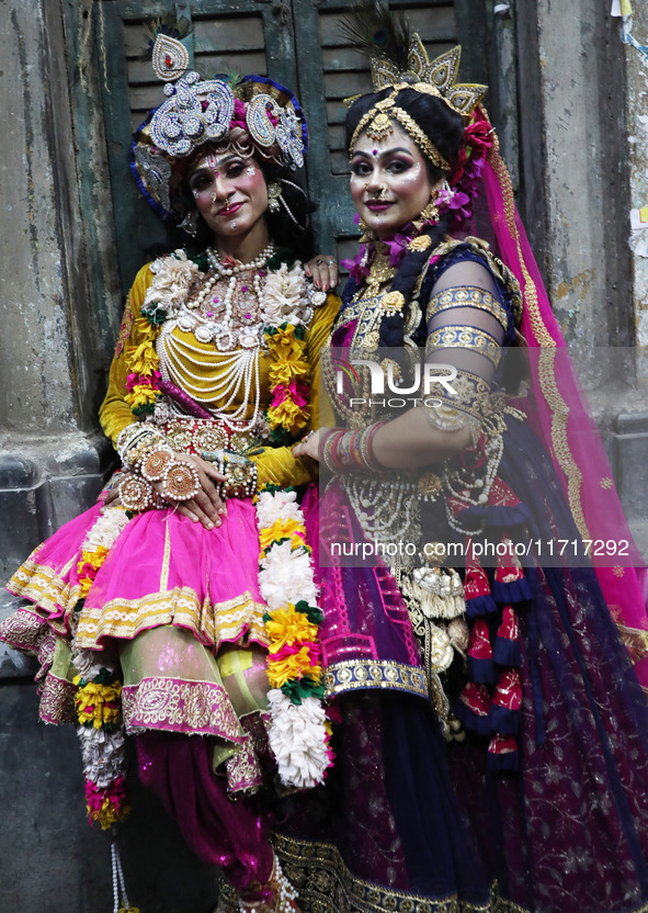 Artists rest after performing an inauguration program next to a ''pandal'' (a temporary platform), a decorated structure, next to an idol of...