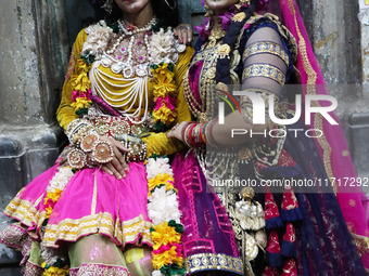 Artists rest after performing an inauguration program next to a ''pandal'' (a temporary platform), a decorated structure, next to an idol of...