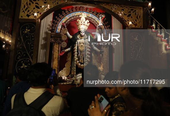 Indian people visit a ''pandal'' (a temporary platform), a decorated structure next to an idol of the Hindu goddess Kali, ahead of the Kali...