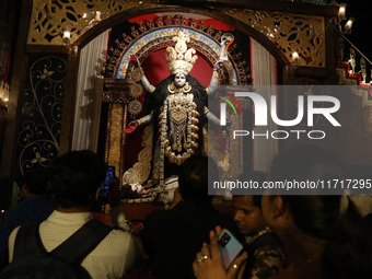 Indian people visit a ''pandal'' (a temporary platform), a decorated structure next to an idol of the Hindu goddess Kali, ahead of the Kali...