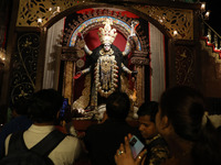 Indian people visit a ''pandal'' (a temporary platform), a decorated structure next to an idol of the Hindu goddess Kali, ahead of the Kali...