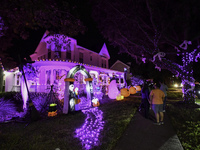 In the backyards of houses in the Celebration, FL, region, people create scary scenes with inflatable and luminous dolls for Halloween on Su...