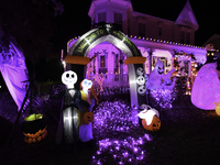 In the backyards of houses in the Celebration, FL, region, people create scary scenes with inflatable and luminous dolls for Halloween on Su...