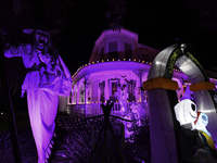 In the backyards of houses in the Celebration, FL, region, people create scary scenes with inflatable and luminous dolls for Halloween on Su...