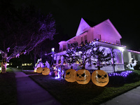 In the backyards of houses in the Celebration, FL, region, people create scary scenes with inflatable and luminous dolls for Halloween on Su...