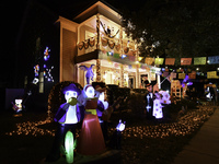 In the backyards of houses in the Celebration, FL, region, people create scary scenes with inflatable and luminous dolls for Halloween on Su...