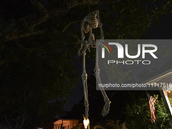 In the backyards of houses in the Celebration, FL, region, people create scary scenes with inflatable and luminous dolls for Halloween on Su...