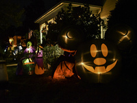 In the backyards of houses in the Celebration, FL, region, people create scary scenes with inflatable and luminous dolls for Halloween on Su...