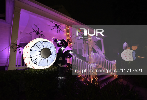 In the backyards of houses in the Celebration, FL, region, people create scary scenes with inflatable and luminous dolls for Halloween on Su...