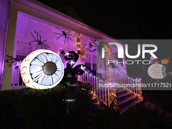 In the backyards of houses in the Celebration, FL, region, people create scary scenes with inflatable and luminous dolls for Halloween on Su...