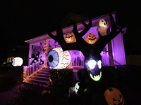 In the backyards of houses in the Celebration, FL, region, people create scary scenes with inflatable and luminous dolls for Halloween on Su...