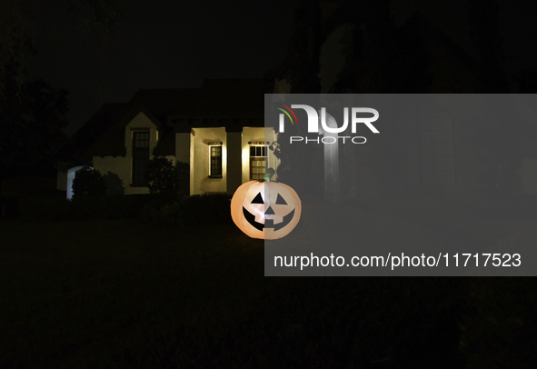 In the backyards of houses in the Celebration, FL, region, people create scary scenes with inflatable and luminous dolls for Halloween on Su...