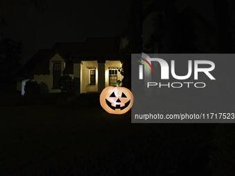 In the backyards of houses in the Celebration, FL, region, people create scary scenes with inflatable and luminous dolls for Halloween on Su...