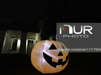 In the backyards of houses in the Celebration, FL, region, people create scary scenes with inflatable and luminous dolls for Halloween on Su...