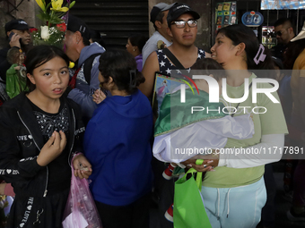 A woman carries a minor dressed as Saint Jude Thaddeus outside the Church of San Hipolito in Mexico City, Mexico, on October 28, 2024. The c...