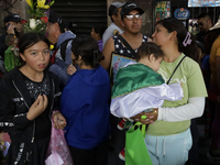 A woman carries a minor dressed as Saint Jude Thaddeus outside the Church of San Hipolito in Mexico City, Mexico, on October 28, 2024. The c...