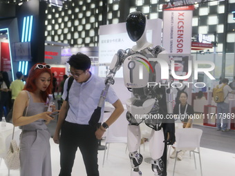 A Unitree robot dog and a model walk on the runway during Fashion Week in Shanghai, China, on October 27, 2024. (