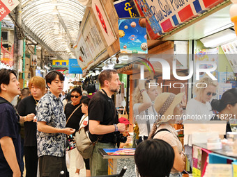 People shop at Heimitsu Shop Street in Naha, Japan, on October 28, 2024. (