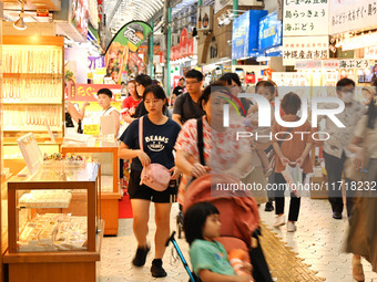 People shop at Heimitsu Shop Street in Naha, Japan, on October 28, 2024. (