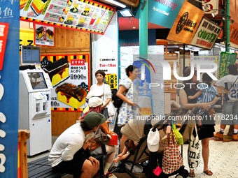 People shop at Heimitsu Shop Street in Naha, Japan, on October 28, 2024. (