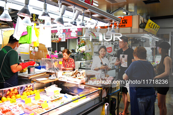 People shop at Heimitsu Shop Street in Naha, Japan, on October 28, 2024. 