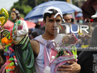 A devotee of Saint Jude Thaddeus attends the Church of San Hipolito to bless the images and give thanks for the favors granted in Mexico Cit...