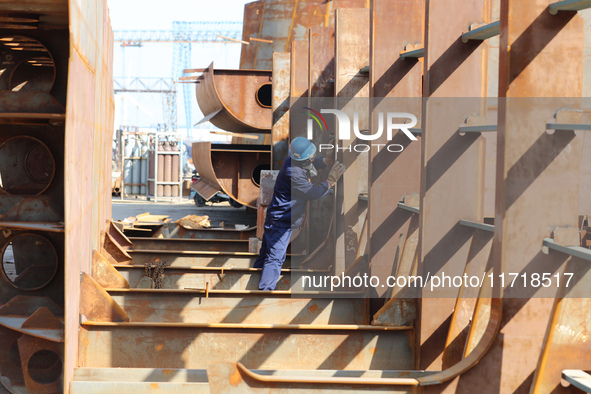 Workers produce ship hulls at Tuangang Community Shipbuilding base in Yanweigang town, Guanyun County, Lianyungang, China, on October 29, 20...