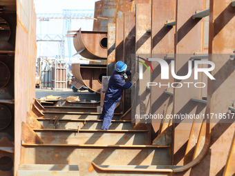 Workers produce ship hulls at Tuangang Community Shipbuilding base in Yanweigang town, Guanyun County, Lianyungang, China, on October 29, 20...