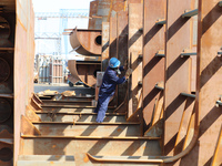 Workers produce ship hulls at Tuangang Community Shipbuilding base in Yanweigang town, Guanyun County, Lianyungang, China, on October 29, 20...