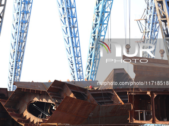 Workers produce ship hulls at Tuangang Community Shipbuilding base in Yanweigang town, Guanyun County, Lianyungang, China, on October 29, 20...