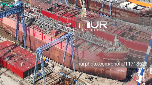 Workers produce ship hulls at Tuangang Community Shipbuilding base in Yanweigang town, Guanyun County, Lianyungang, China, on October 29, 20...