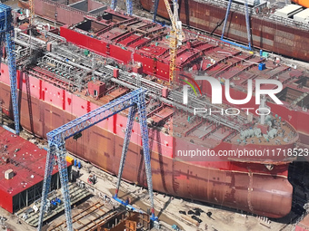 Workers produce ship hulls at Tuangang Community Shipbuilding base in Yanweigang town, Guanyun County, Lianyungang, China, on October 29, 20...