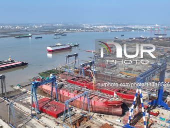 Workers produce ship hulls at Tuangang Community Shipbuilding base in Yanweigang town, Guanyun County, Lianyungang, China, on October 29, 20...