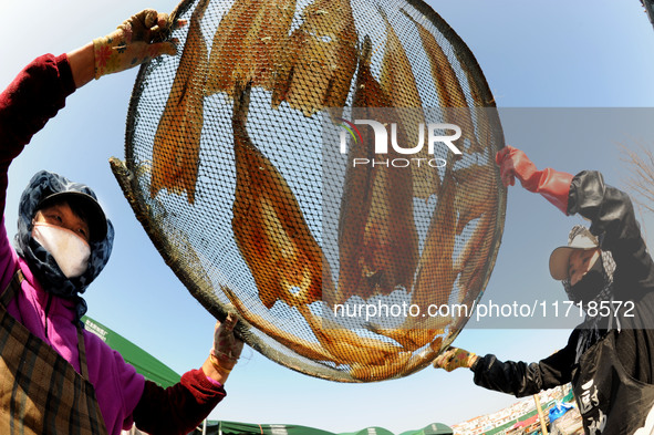 Fishermen dry fish at the fishing port of Xiliandao village in Lianyungang, China, on October 29, 2024. 