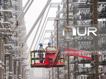 Power maintenance personnel overhaul the equipment of Guquan converter station in Xuancheng, China, on October 29, 2024. (