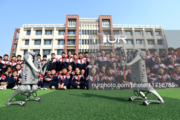 Primary school students interact with a robot dog in Handan, China, on October 29, 2024. 