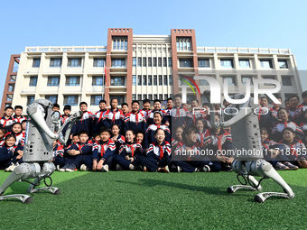 Primary school students interact with a robot dog in Handan, China, on October 29, 2024. (