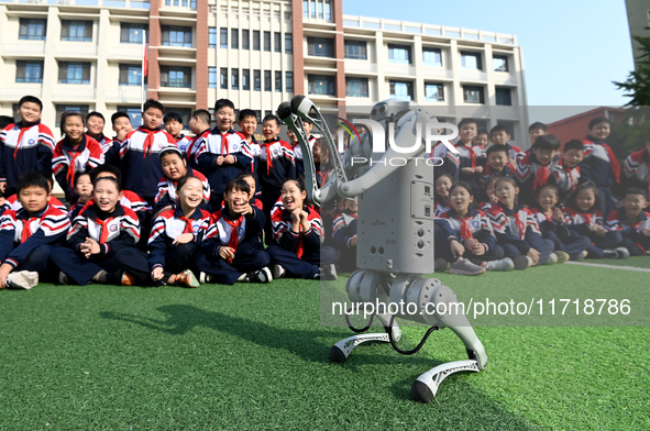 Primary school students interact with a robot dog in Handan, China, on October 29, 2024. 