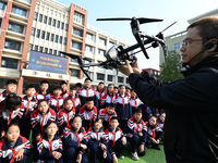 A staff member introduces a drone to primary school students in Handan, China, on October 29, 2024. (