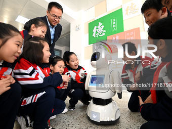 Primary school students talk and interact with a robot in Handan, China, on October 29, 2024. (