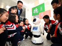 Primary school students talk and interact with a robot in Handan, China, on October 29, 2024. (