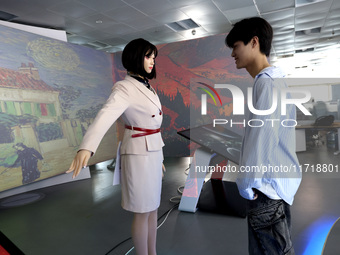 A citizen interacts with Tang Yu, a Netdragon AI robot, at the Netdragon Base of Digital Education Town in Changle District in Fuzhou, China...