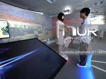 A citizen interacts with Tang Yu, a Netdragon AI robot, at the Netdragon Base of Digital Education Town in Changle District in Fuzhou, China...