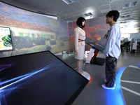 A citizen interacts with Tang Yu, a Netdragon AI robot, at the Netdragon Base of Digital Education Town in Changle District in Fuzhou, China...