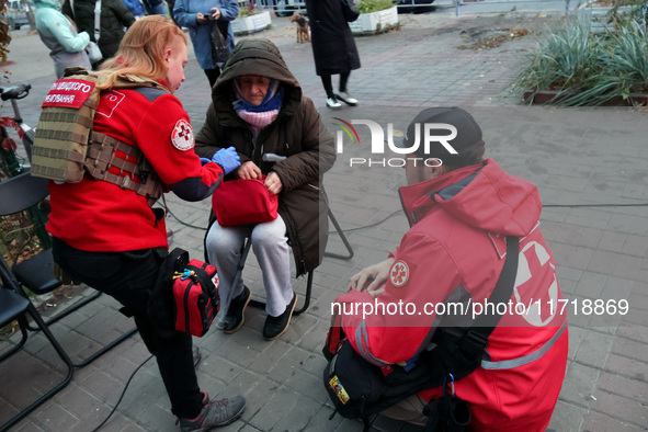 Paramedics help an elderly woman in the Solomianskyi district after a Russian drone attack in Kyiv, Ukraine, on October 29, 2024. Six people...