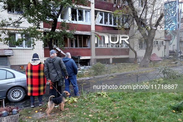 Onlookers stand outside an apartment block in the Solomianskyi district damaged by a Russian drone attack in Kyiv, Ukraine, on October 29, 2...