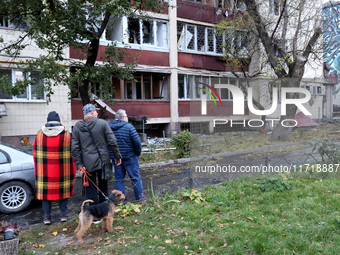 Onlookers stand outside an apartment block in the Solomianskyi district damaged by a Russian drone attack in Kyiv, Ukraine, on October 29, 2...