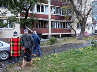 Onlookers stand outside an apartment block in the Solomianskyi district damaged by a Russian drone attack in Kyiv, Ukraine, on October 29, 2...